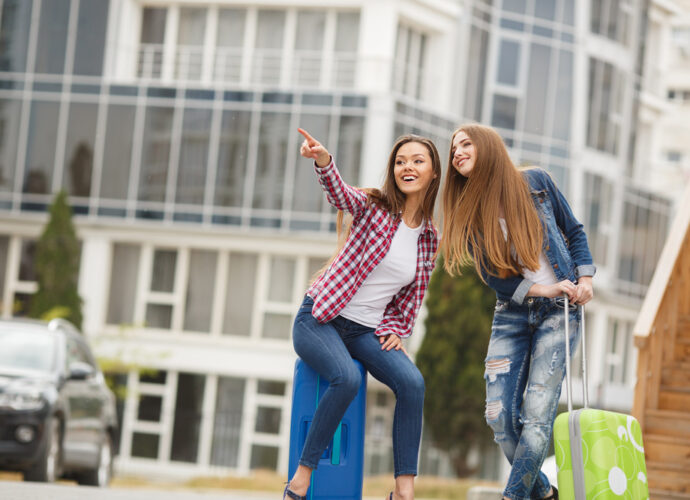 Deux étudiantes arrivent dans une résidence moderne à Orléans avec leurs valises, illustrant le dynamisme du marché de l'immobilier à Orléans.