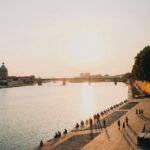 Coucher de soleil sur la Garonne avec promeneurs, idéal pour investir à Toulouse.