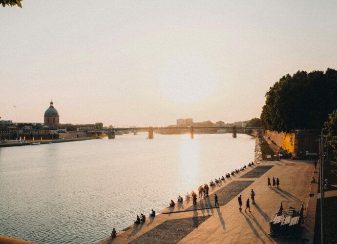 Coucher de soleil sur la Garonne avec promeneurs, idéal pour investir à Toulouse.